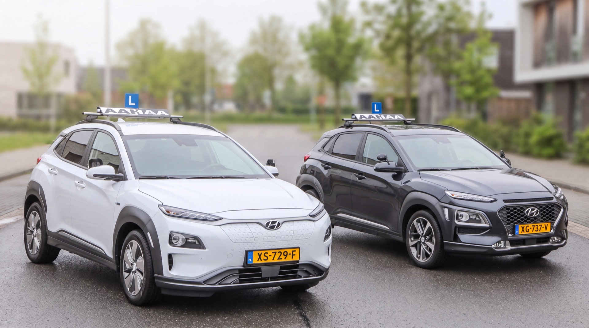 De twee Hyundai Kona lesauto's van Rijschool AAHAA met het AAHAA-bord op het dak