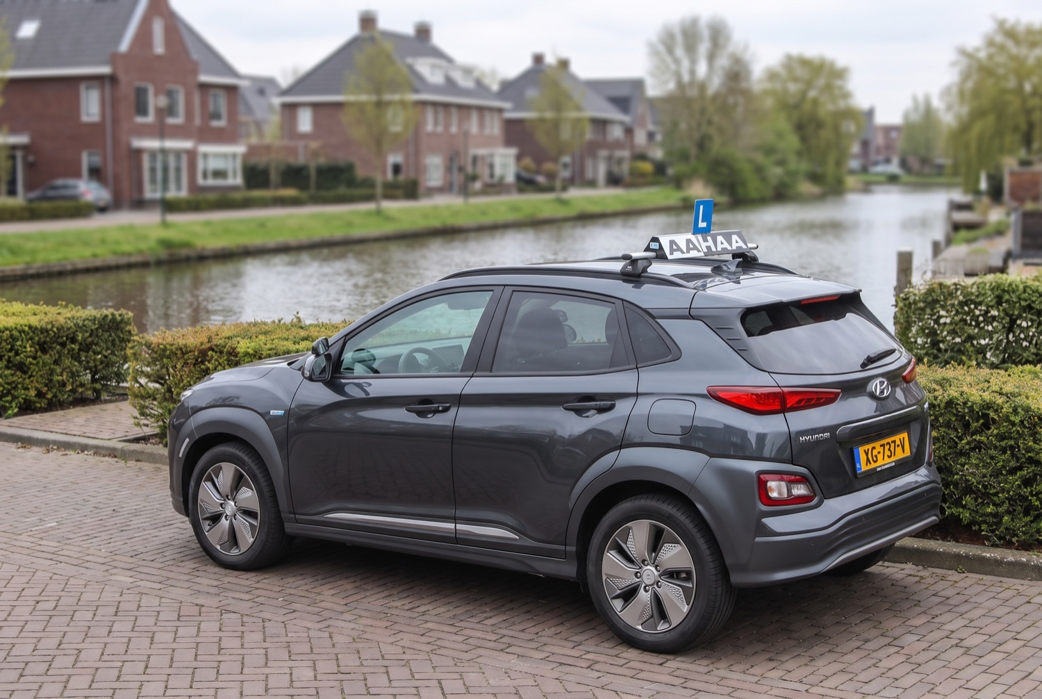 De antracieten Hyundai Kona lesauto van Rijschool AAHAA in een woonwijk in Nieuwegein